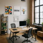 Lys og moderne kontorindretning med skrivebord, computer, kontorstole og grønne planter. Væggen er dekoreret med kreative plakater, herunder en pæreillustration og ordet "CREATIVE".